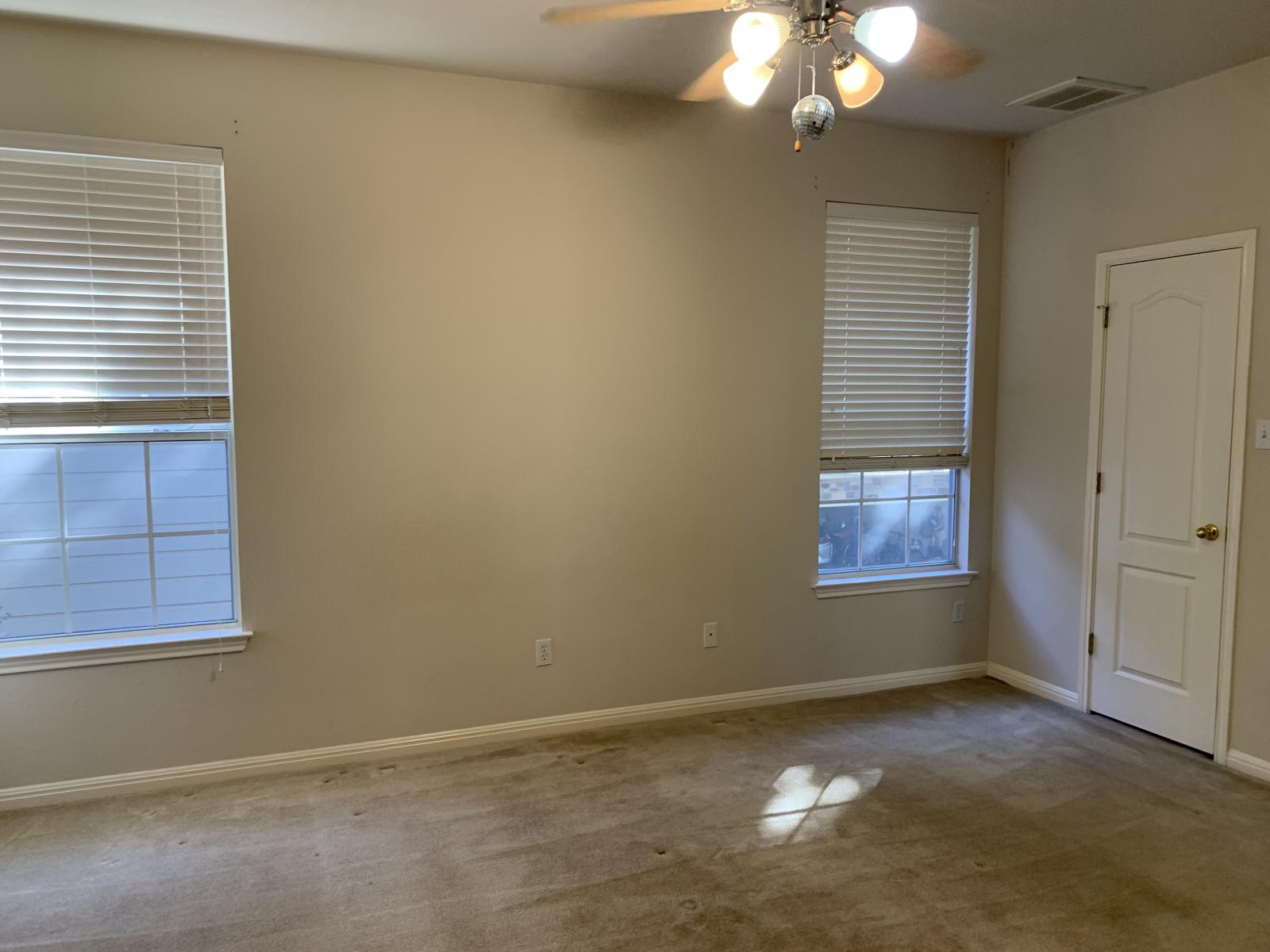 11000 Anderson Mill Road, Unit 29 Austin, TX 78750 - Photo 22 of 27 an empty room with windows and chandelier fan