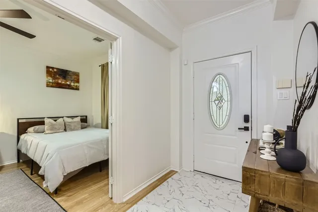 a bedroom with a bed a clock on the wall and dresser