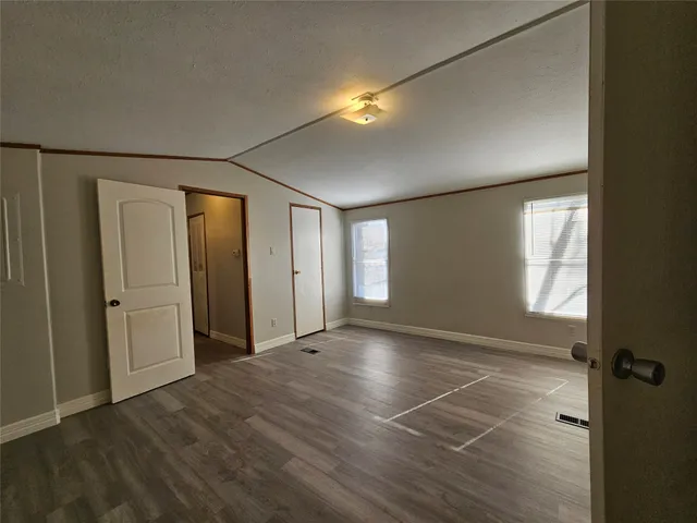 a view of an empty room with window and closet area