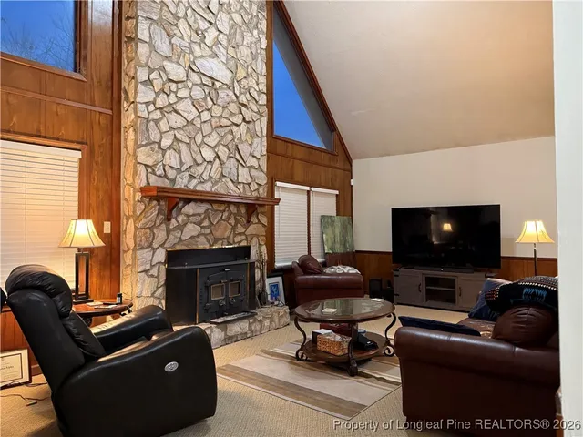 a living room with furniture a fireplace and a flat screen tv