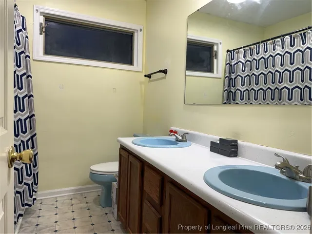 a bathroom with a sink a toilet and mirror