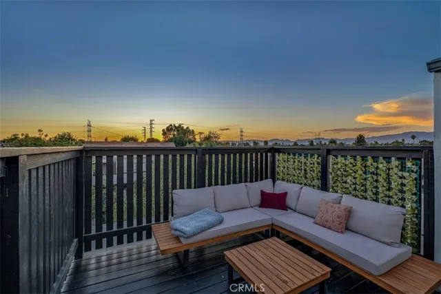 a roof deck with couches and wooden floor