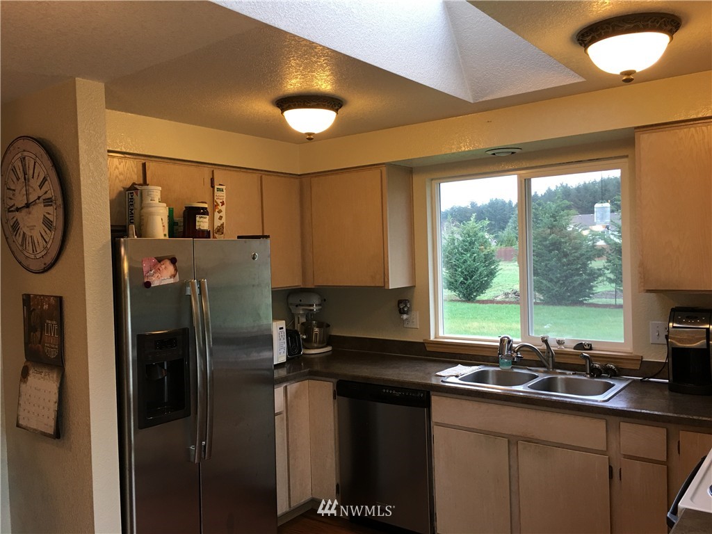 18234 Tamara Lane Southwest Rochester, WA 98579 - Photo 18 of 25 a kitchen with stainless steel appliances granite countertop a sink a refrigerator and a granite counter top