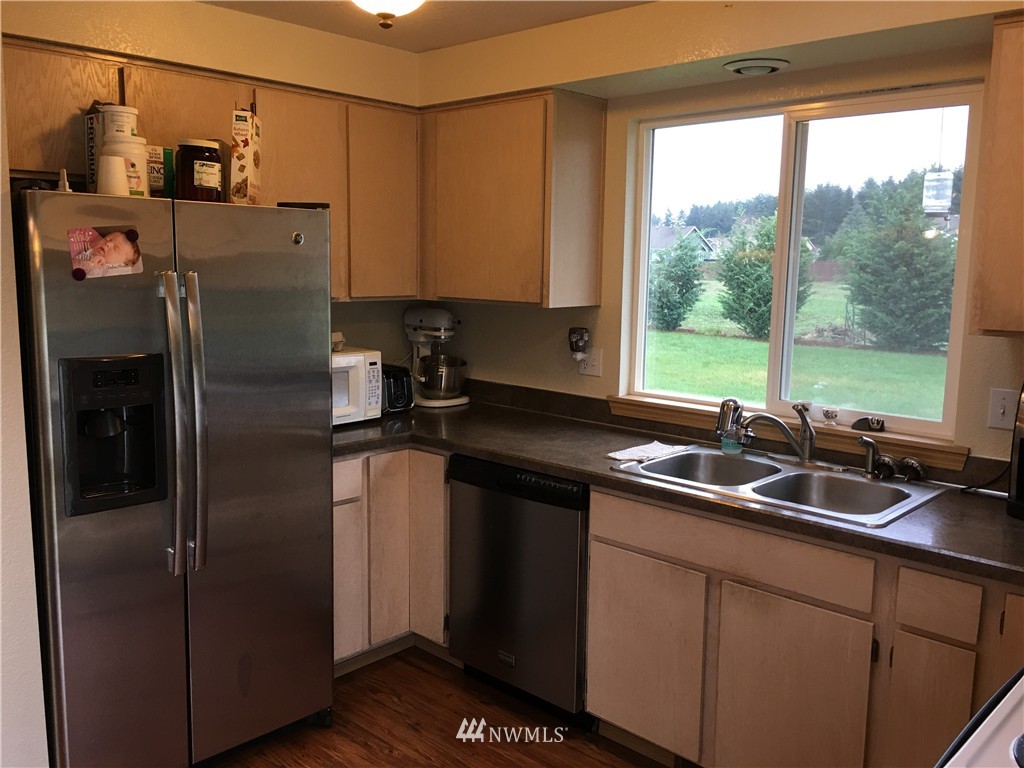 18234 Tamara Lane Southwest Rochester, WA 98579 - Photo 21 of 25 a kitchen with stainless steel appliances a sink and a large window