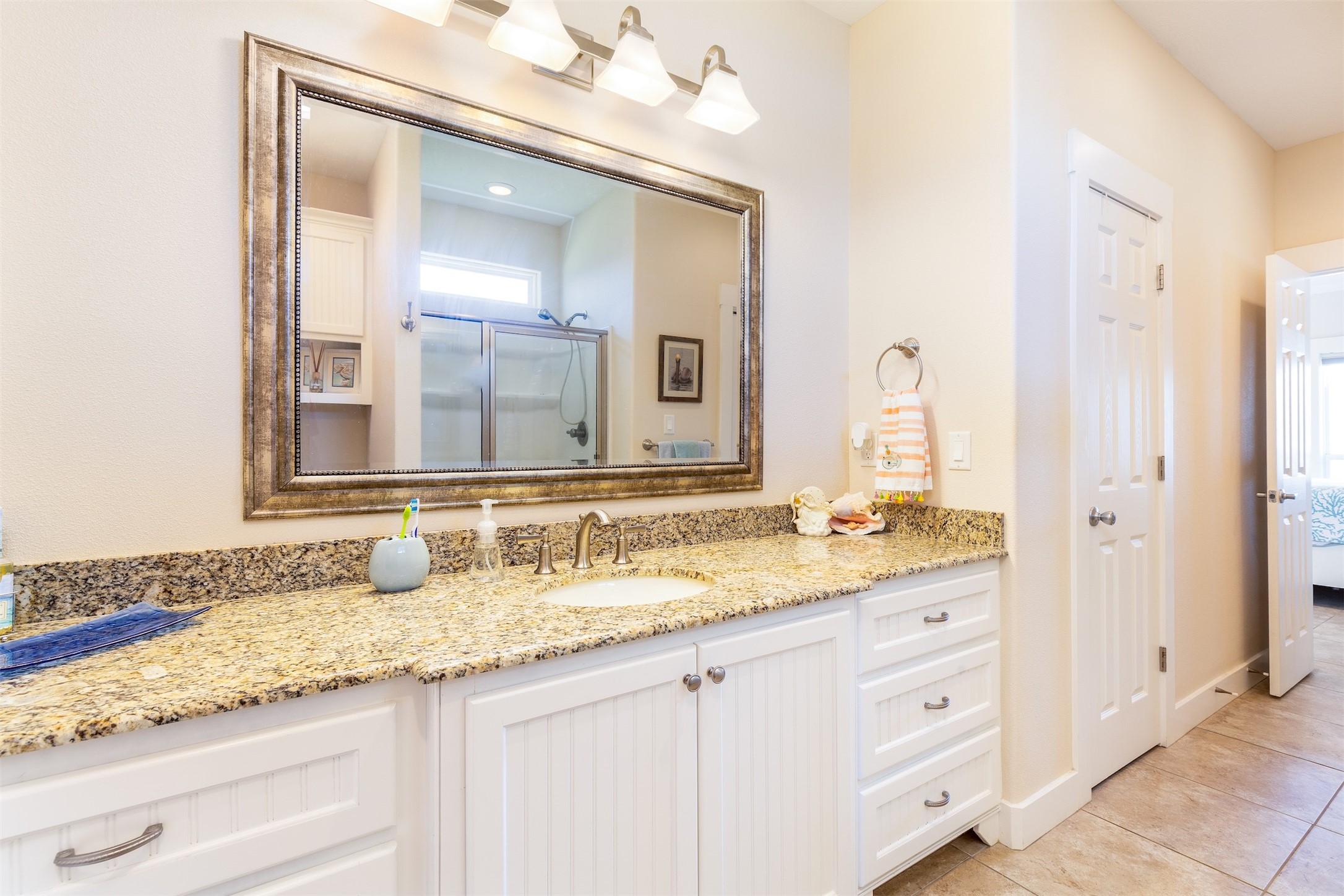 2383 Sandpiper Crystal Beach, TX 77650 - Photo 12 of 39 Primary bathroom has granite countertops, lots of storage, and beautifully framed mirror.