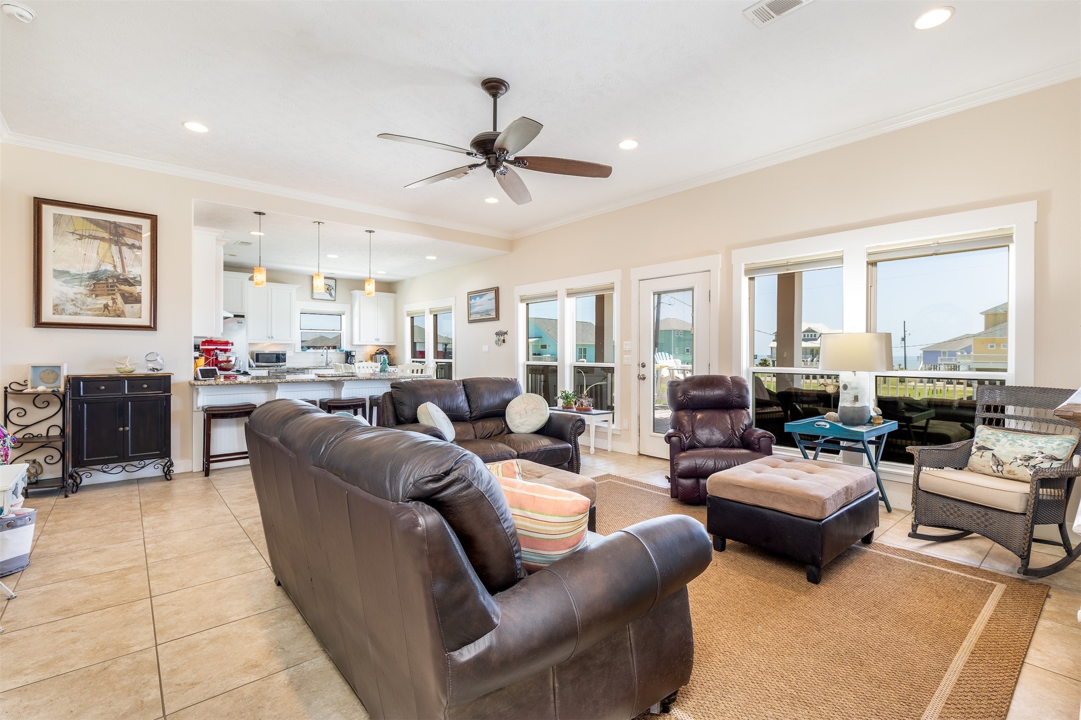 2383 Sandpiper Crystal Beach, TX 77650 - Photo 2 of 39 The living room flows right into the kitchen with tile throughout the house. Large windows that look out onto the extended patio.
