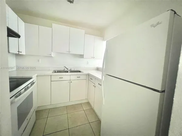 a kitchen with cabinets appliances a sink and a counter top space