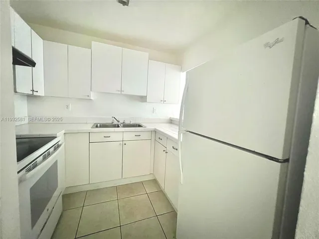 a kitchen with cabinets appliances a sink and a counter top space