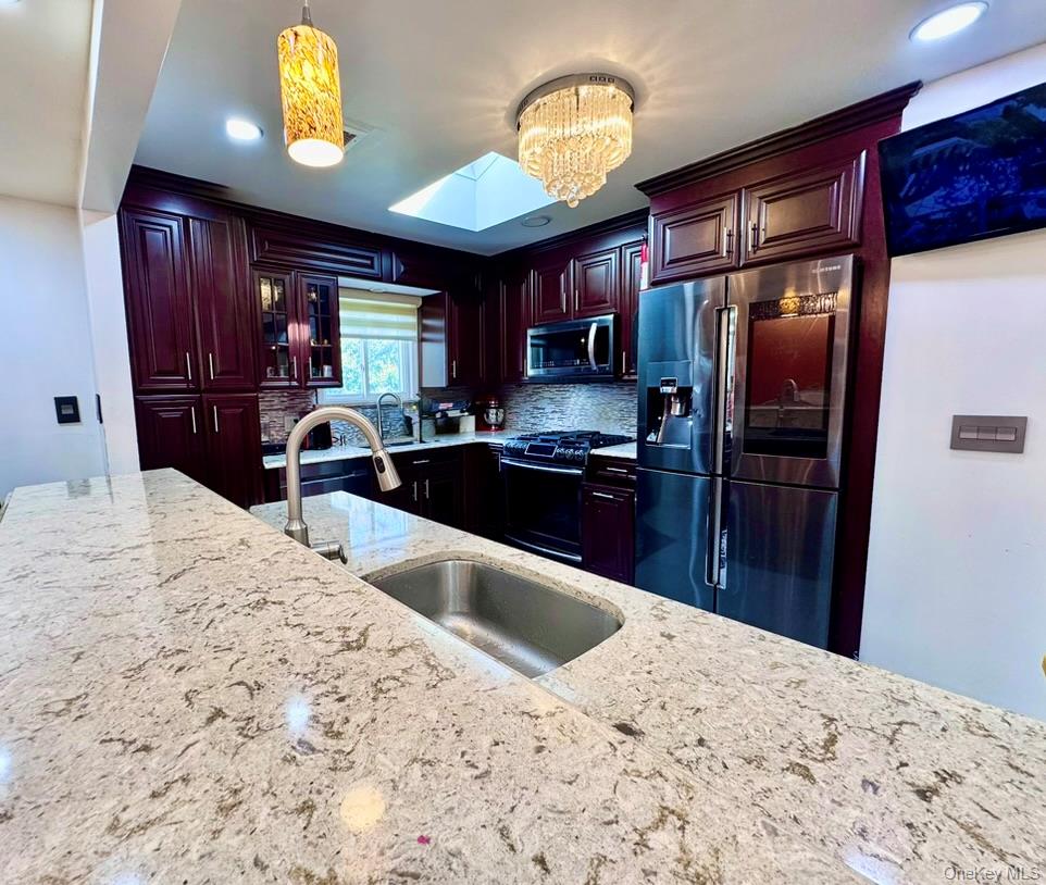 62 Walnut Road Inwood, NY 11096 - Photo 11 of 31 a kitchen with stainless steel appliances kitchen island granite countertop a refrigerator stove top oven and sink