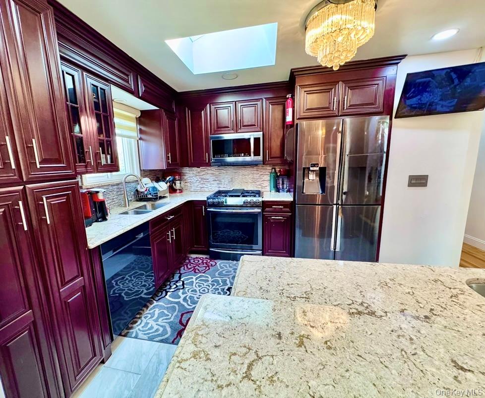 62 Walnut Road Inwood, NY 11096 - Photo 10 of 31 a kitchen with stainless steel appliances kitchen island granite countertop a refrigerator stove top oven and sink