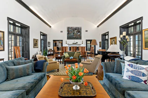 a living room with furniture kitchen view and large windows