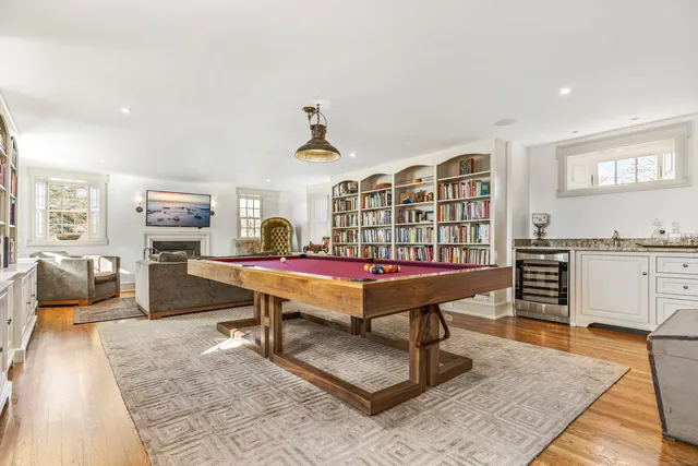 a living room with furniture a flat screen tv and pool table