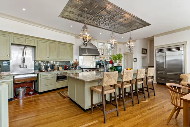a kitchen with stainless steel appliances granite countertop a kitchen island a stove a table and chairs