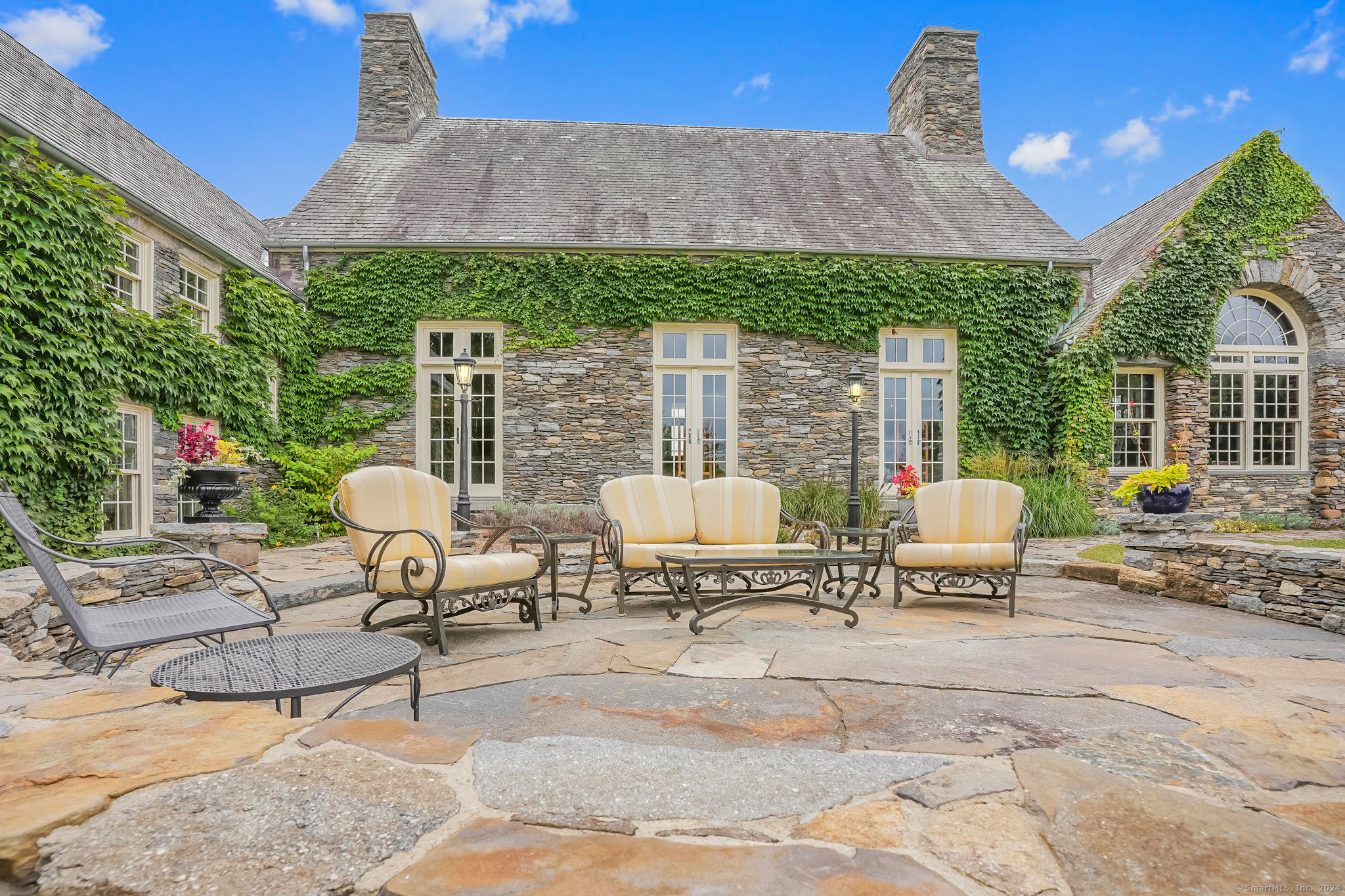 153 Ferry Road Lyme, CT 06371 - Photo 8 of 32 a view of a patio with a dining table and chairs with a fire pit and a fire pit