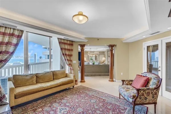 a dining room with furniture a chandelier and kitchen view