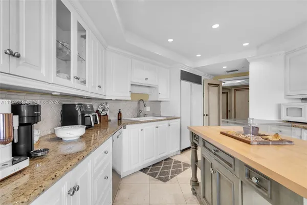 a kitchen with a stove a sink a kitchen island with chairs and wooden floor