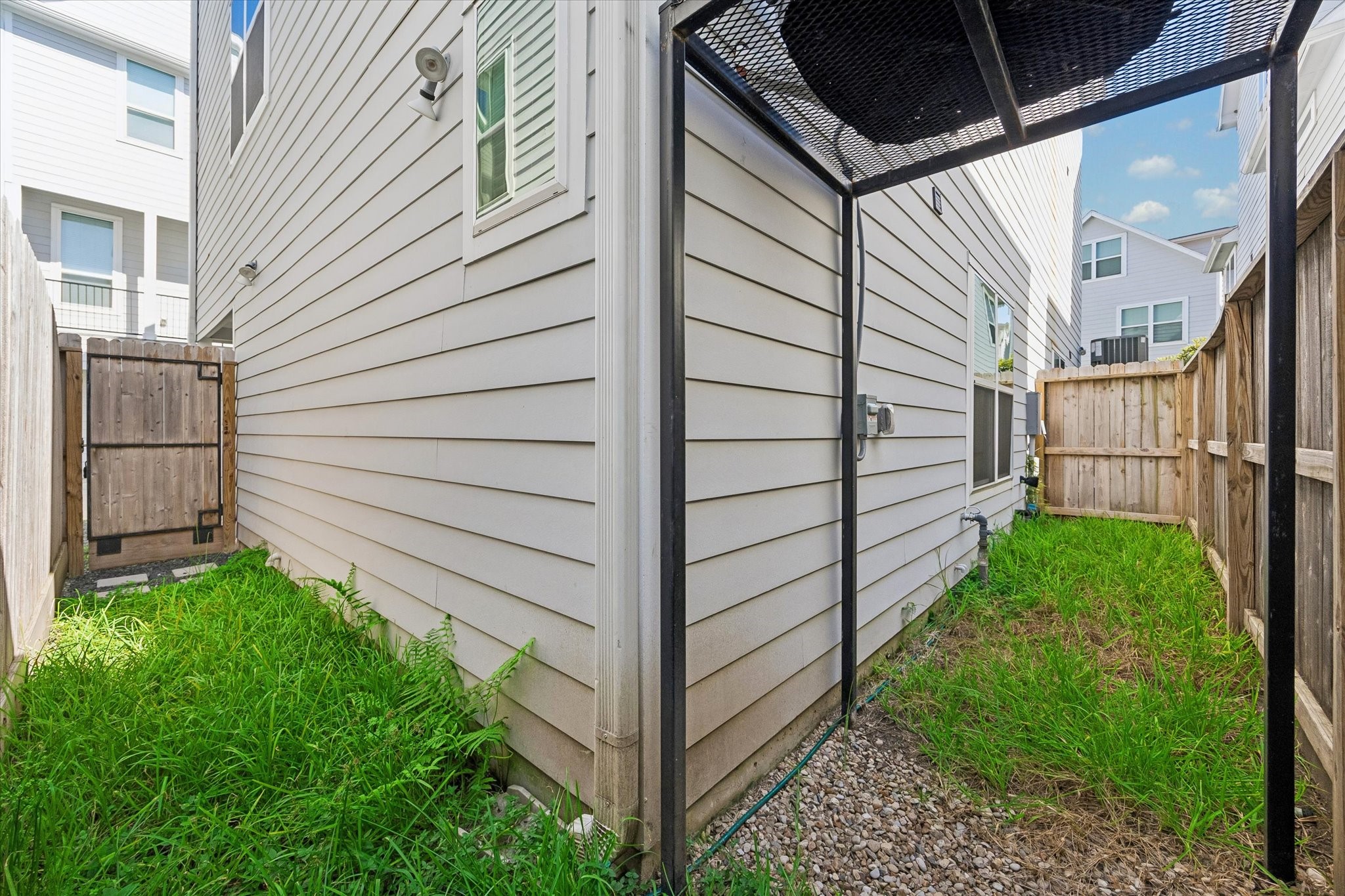 603 Link Road, Unit F Houston, TX 77009 - Photo 24 of 37 Private outdoor side yard offers a rare bit of green space for townhome living, with room for pets or a small outdoor setup. Direct access from the home adds everyday convenience without the upkeep of a large yard.