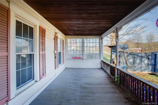 a view of a porch with wooden floor and windows