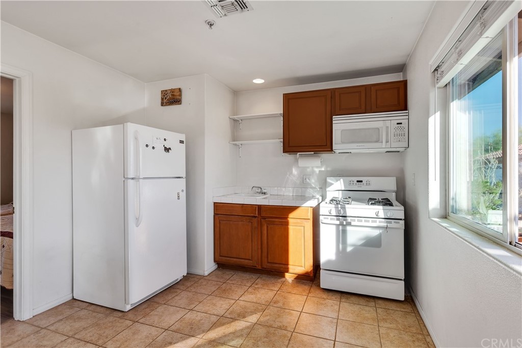 62401 Sunflower Road Joshua Tree, CA 92252 - Photo 34 of 75 a kitchen with stainless steel appliances granite countertop a refrigerator and a stove top oven