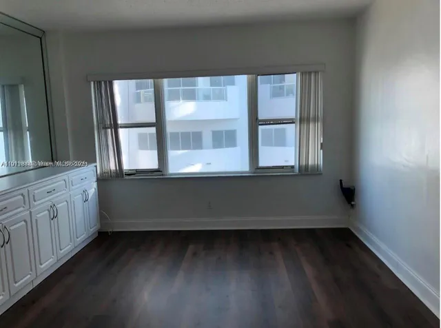 a view of kitchen with granite countertop white cabinets and black appliances