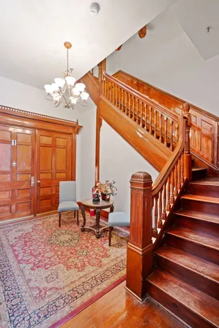 a view of a hallway with wooden floor and stairs