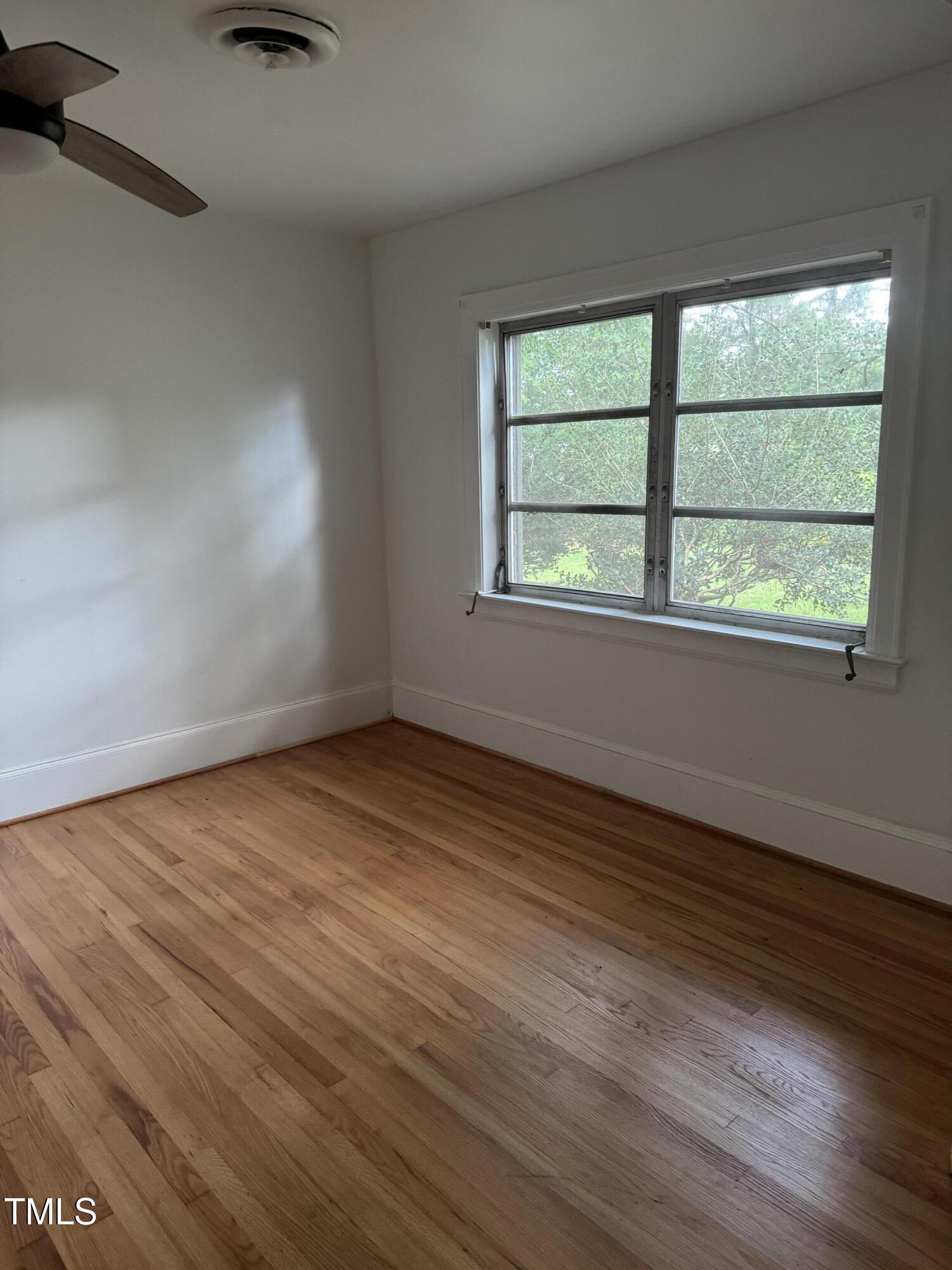 324 Bank Street Roper, NC 27970 - Photo 2 of 21 an empty room with wooden floor and windows