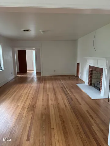wooden floor in an empty room with a fireplace