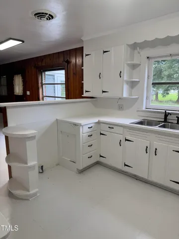 a kitchen with cabinets appliances and a window