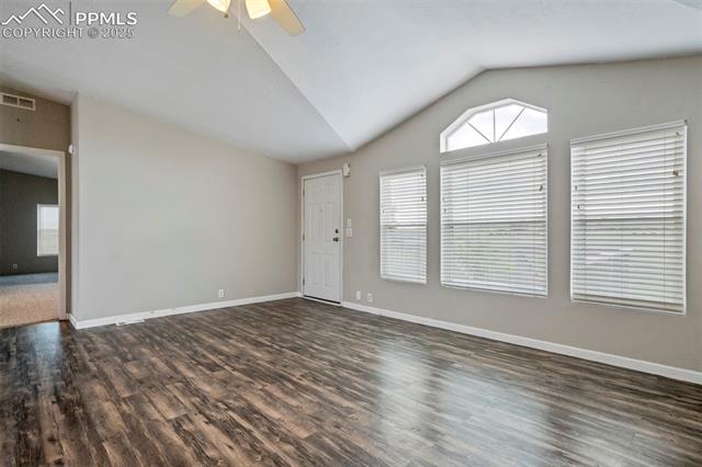 20150 Enoch Road Colorado Springs, CO 80928 - Photo 11 of 50 Unfurnished living room featuring lofted ceiling, wood finished floors, a ceiling fan, and baseboards