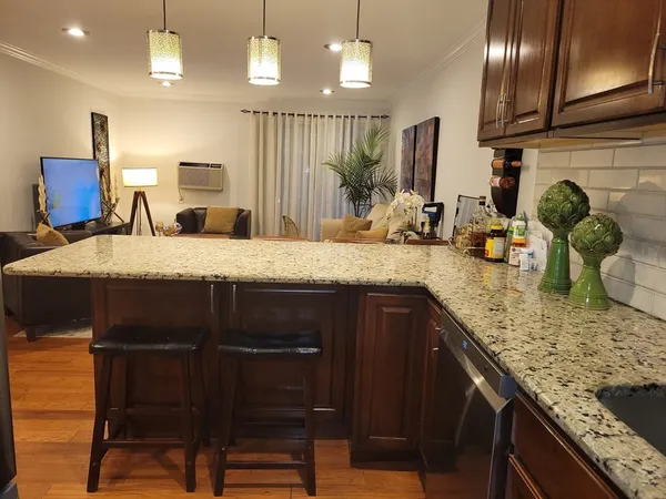 a kitchen with kitchen island granite countertop wooden cabinets and a granite counter tops
