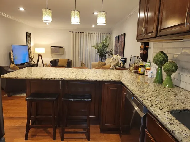a kitchen with kitchen island granite countertop wooden cabinets and a granite counter tops