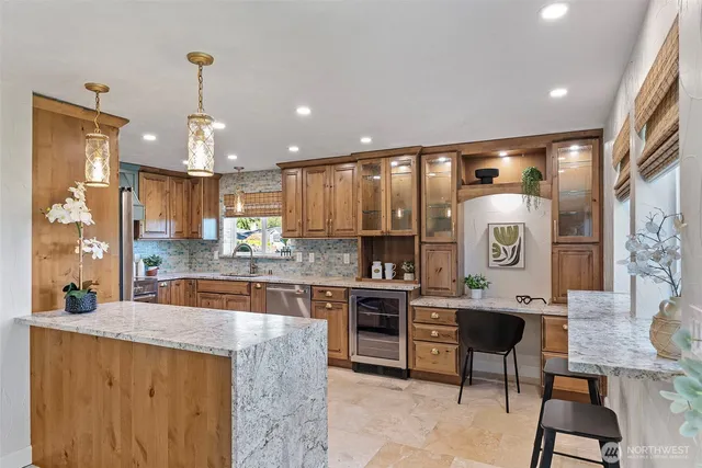 a kitchen with a sink a stove and wooden cabinets