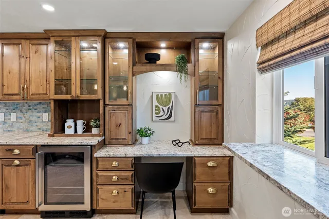 a kitchen with stainless steel appliances granite countertop wooden cabinets a sink and dishwasher a stove a refrigerator with wooden cabinets