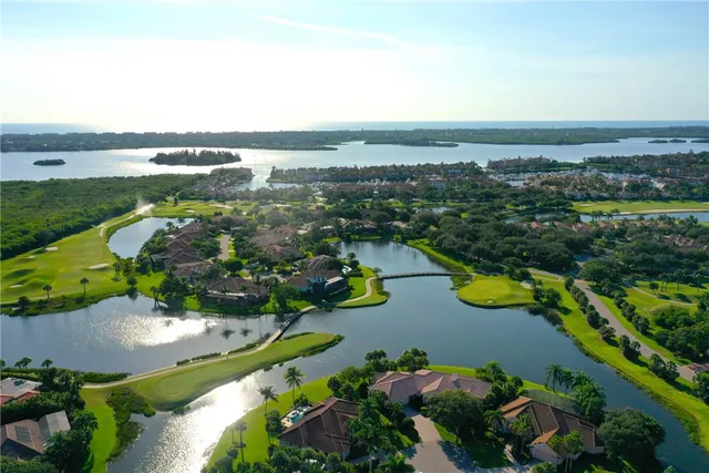 an aerial view of ocean and residential houses with outdoor space