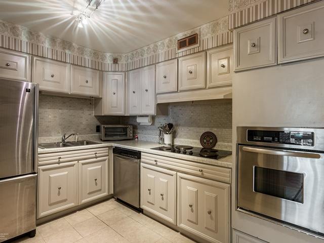 5901 North Sheridan Road, Unit 6G Chicago, IL 60660 - Photo 12 of 24 a kitchen with cabinets appliances a sink and a stove