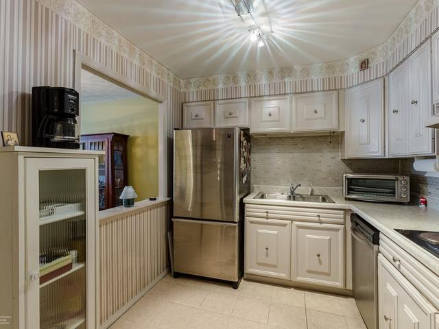5901 North Sheridan Road, Unit 6G Chicago, IL 60660 - Photo 13 of 24 a kitchen with white cabinets and stainless steel appliances