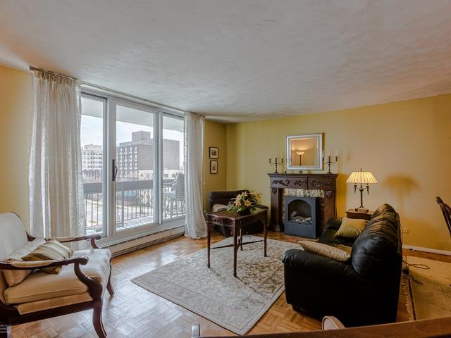 5901 North Sheridan Road, Unit 6G Chicago, IL 60660 - Photo 6 of 24 a living room with furniture a fireplace and large windows