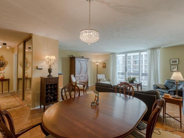 5901 North Sheridan Road, Unit 6G Chicago, IL 60660 - Photo 10 of 24 a dining room with wooden floor a chandelier a wooden table and chairs