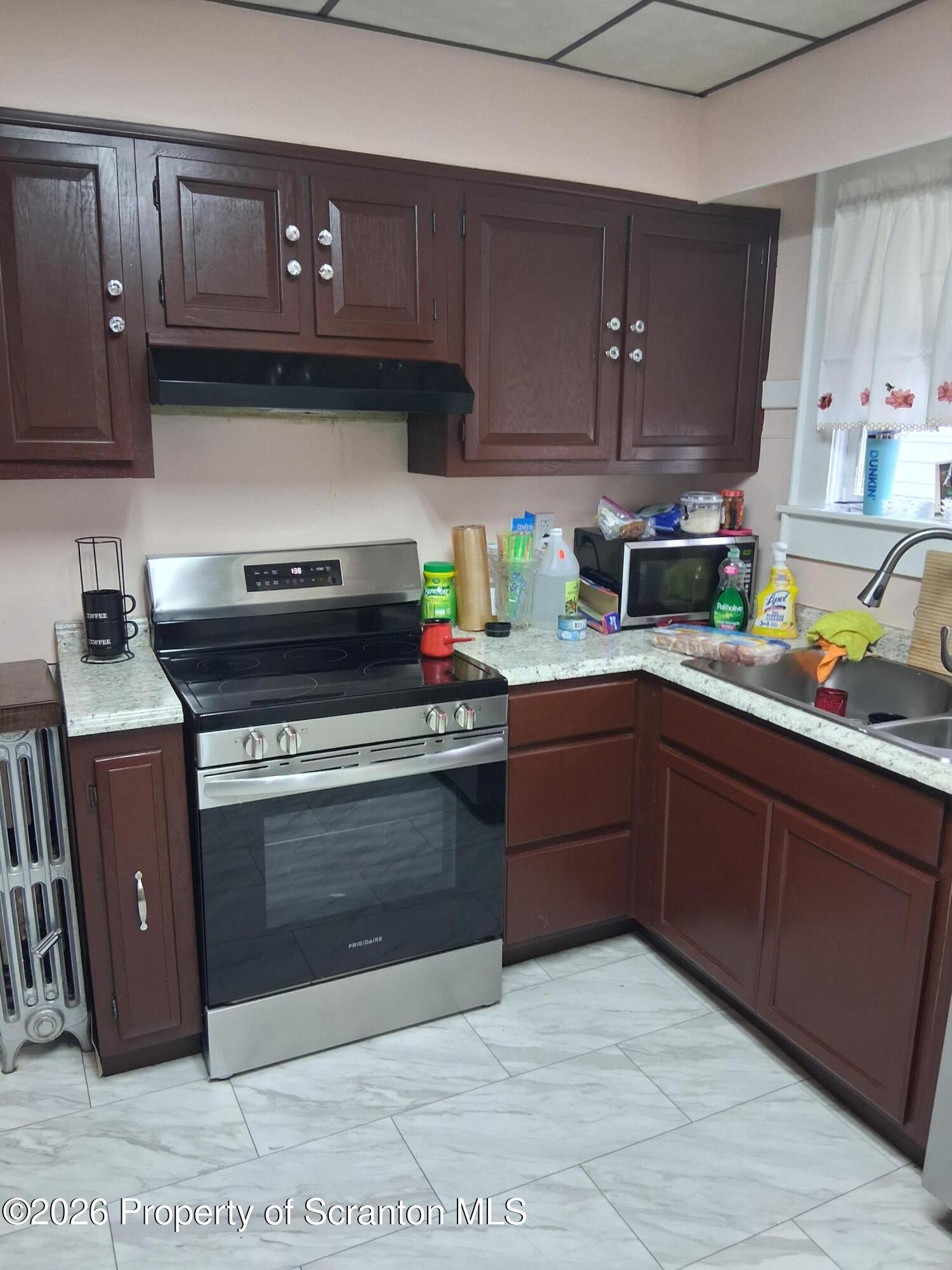 611 Moosic Street Scranton, PA 18505 - Photo 11 of 24 a kitchen with stainless steel appliances granite countertop a stove a sink and a microwave