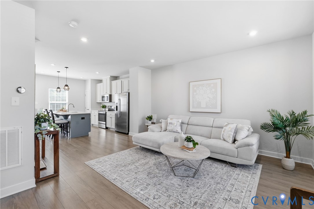 Open-concept living area featuring wood-finish flo