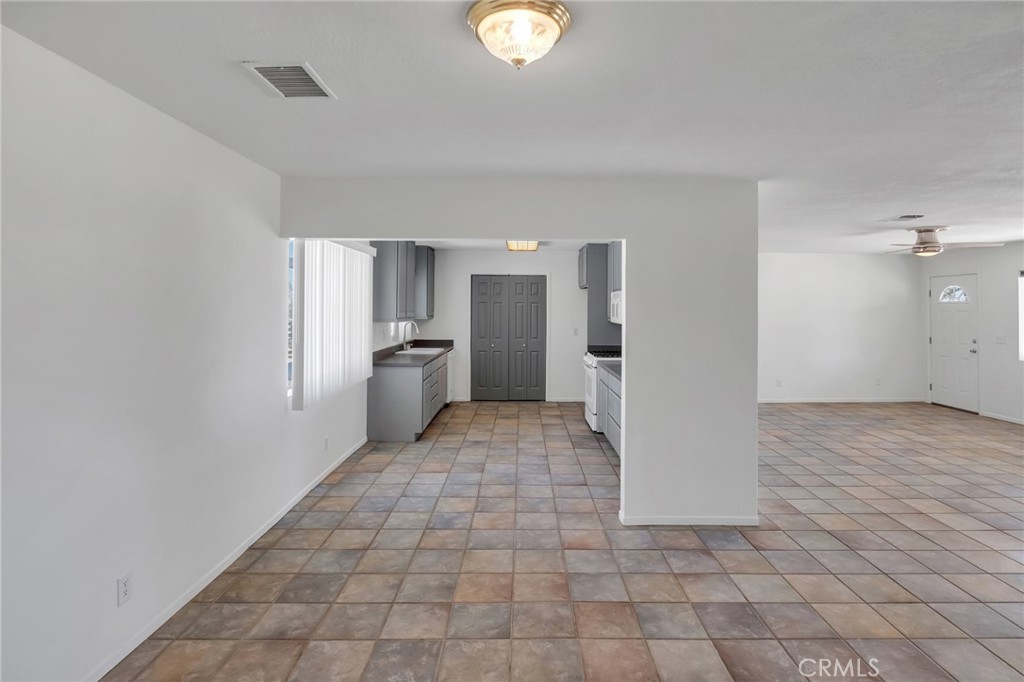 12736 Oasis Road Pinon Hills, CA 92372 - Photo 10 of 33 a view of a refrigerator in kitchen and an empty room