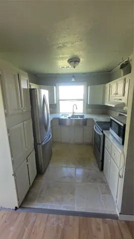 a kitchen with a sink a stove and a refrigerator