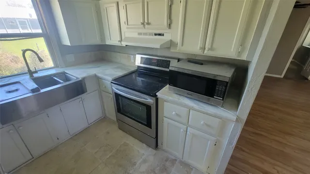 a view of a hallway with wooden floor and a chandelier