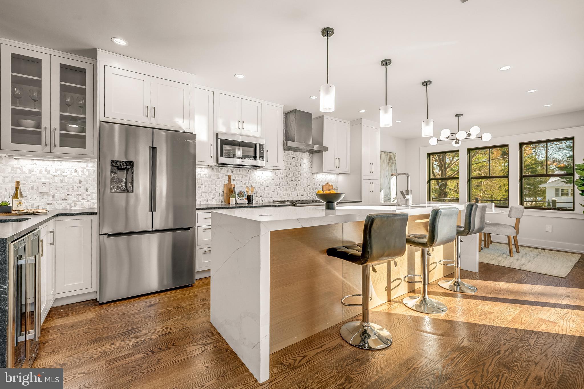 5921 Chesterbrook Road McLean, VA 22101 - Photo 21 of 76 a kitchen with stainless steel appliances granite countertop a refrigerator a stove and a wooden floors