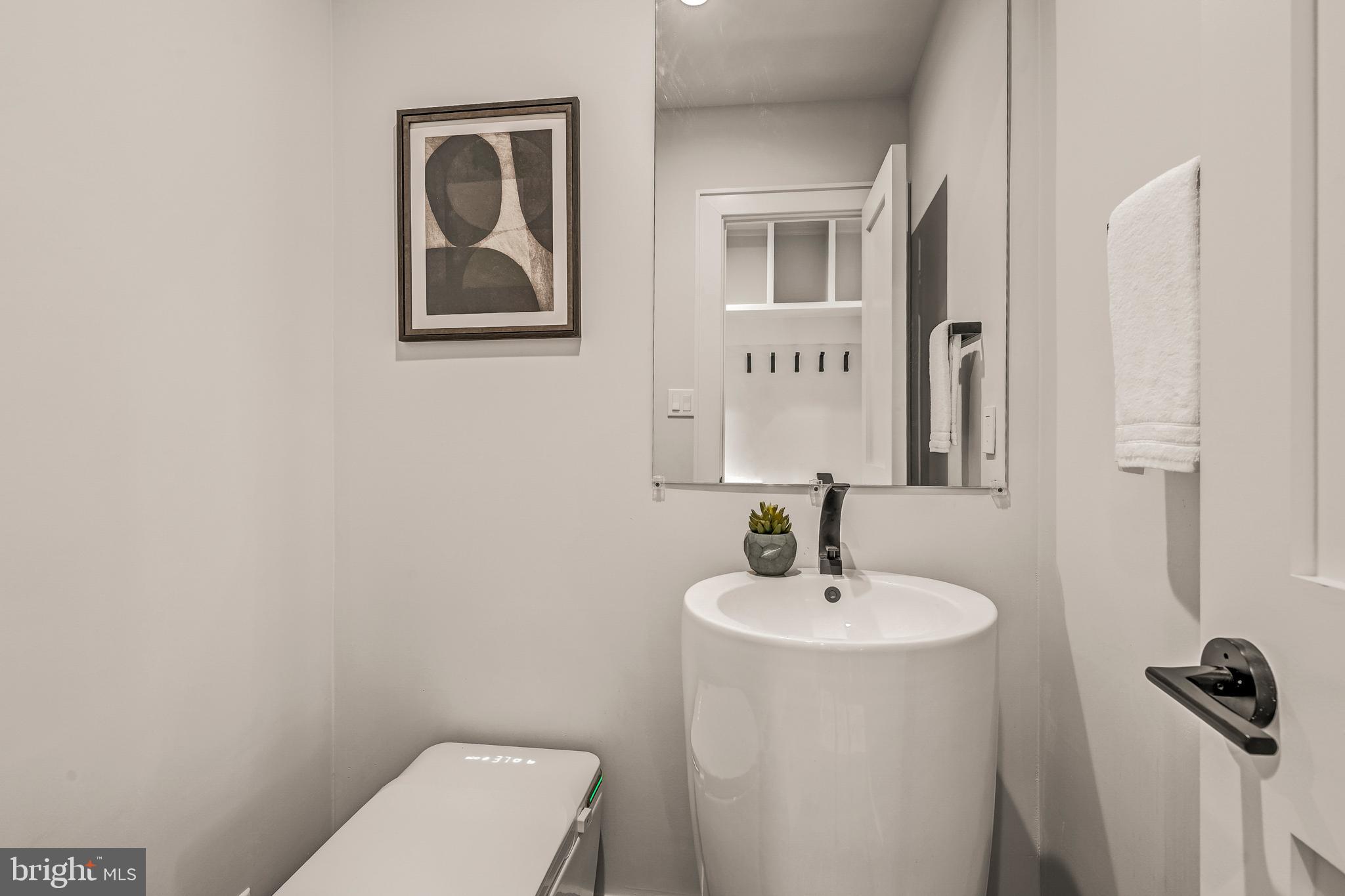 5921 Chesterbrook Road McLean, VA 22101 - Photo 35 of 76 a bathroom with a toilet sink and mirror