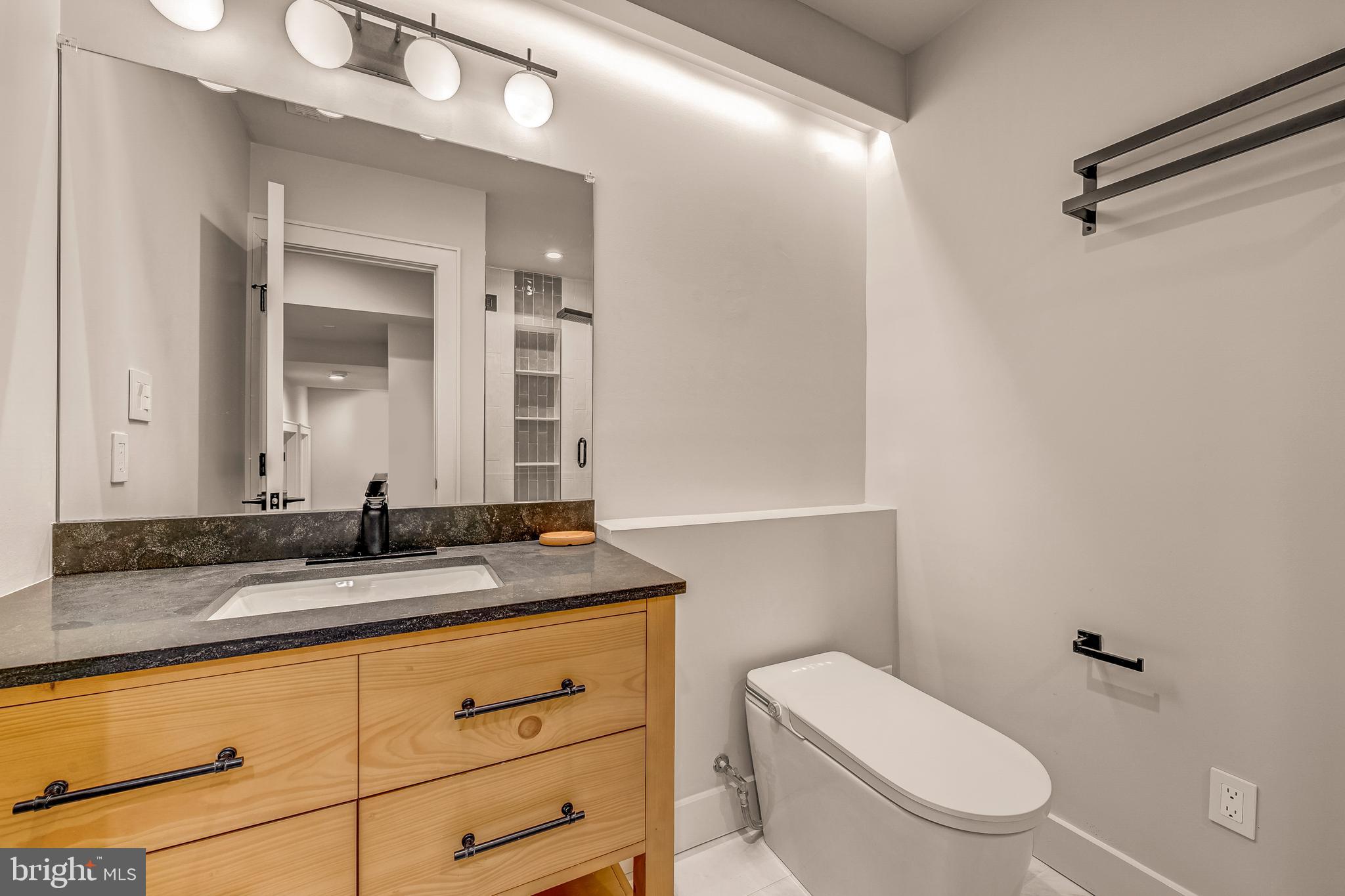 5921 Chesterbrook Road McLean, VA 22101 - Photo 54 of 76 a bathroom with a granite countertop sink mirror vanity and toilet