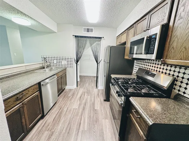 a kitchen with stainless steel appliances granite countertop a stove and a refrigerator