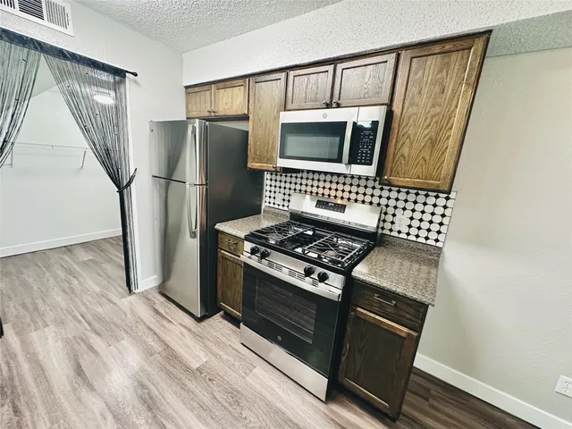 a kitchen with granite countertop a stove and a refrigerator