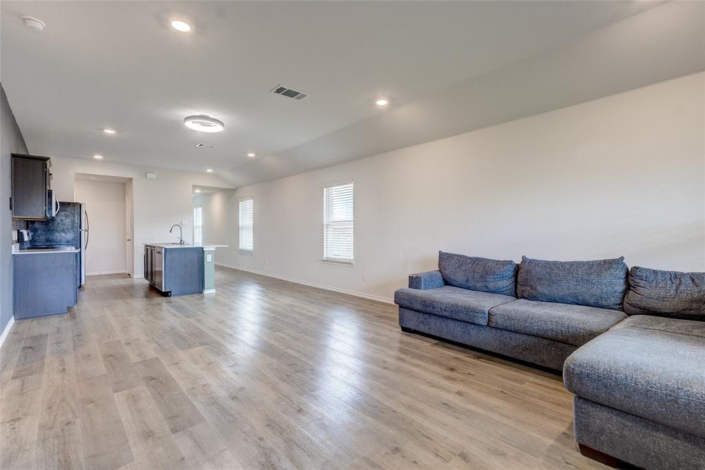 1016 Rio Bravo Drive Forney, TX 75126 - Photo 11 of 25 Spacious open-concept living area featuring wood-finish flooring, recessed lighting, and ample natural light from multiple windows