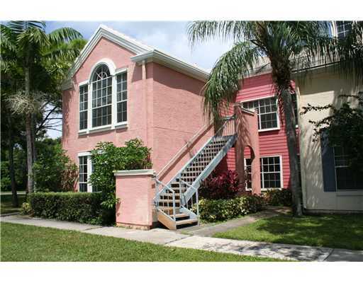 1335 Crystal Way, Unit J Delray Beach, FL 33444 - Photo 1 of 6 a front view of a house with a garden and plants